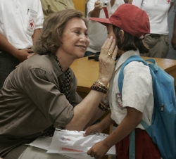 Doña Sofía saluda a una niña durante la visita a la Escuela Hilisimaetano, construida con la colaboración de Cruz Roja Española en la Isla de Nías