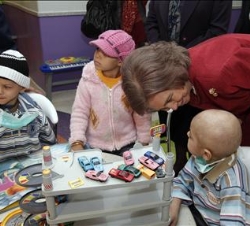 Su Majestad la Reina charla con un niño durante su visita al Hospital Oncológico de El Cairo