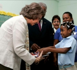 Su Majestad conversa con una niña durante su visita al Colegio Angélica Massé de Santo Domingo