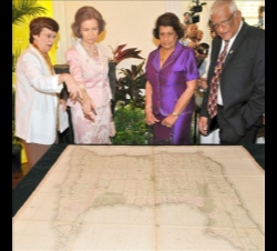 La Reina, acompañada por la Primera Dama de Trinidad y Tobago, observa unos documentos históricos españoles en la Universidad de las Indias Occidental