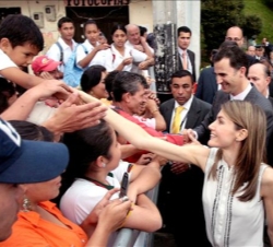 Don Felipe y Doña Letizia saludan a los numerosos vecinos del barrio de Santo Domingo de Medellín que les brindaron una cariñosa bienvenida
