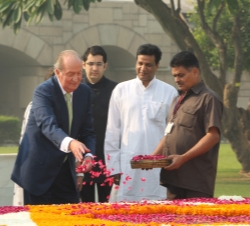 Don Juan Carlos deposita unos petalos sobre la lámina de agua del mausoleo de Mahatma Gandhi