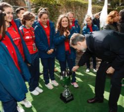 Su Majestad el Rey contempla el trofeo que acredita a la selección femenina de rugby XV como vencedoras del Campeonato de Europa
