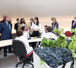 Su Majestad la Reina conversa con los alumnos que realizan la práctica de cata de uvas durante su visita