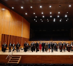 Sus Majestades los Reyes y Sus Altezas Reales la Princesa de Asturias y la Infanta Doña Sofía acompañados de los miembros de la Orquesta Sinfónica del Principado de Asturias (OSPA) en el escenario del Auditorio