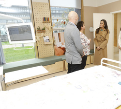 Su Majestad la Reina acompañada por la Princesa Mary en una habitación del módulo piloto del nuevo Hospital Mary Elisabeth