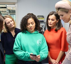 Su Majestad la Reina junto Su Majestad la Reina de Países Bajos observan una presentación en un móvil durante su visita