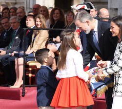 Don Felipe y Doña Letizia reciben, de manos de unos niños, la Bandera de la Policía Nacional tras el plegado solemne de la misma