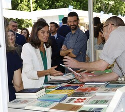Doña Letizia atiende a la presentación de un libro en uno de los puestos de la Feria