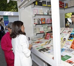 Doña Letizia observa los libros expuestos en el stand de Ecobook de la Feria