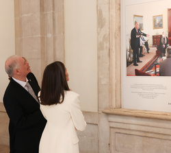 Su Majestad la Reina observa una de las fotografías de la muestra