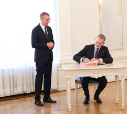 Su Majestad el Rey, en el Salón Blanco del Castillo de Riga, firma en el Libro de Honor en presencia de Su Excelencia el Presidente de la República de