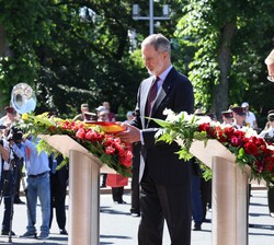 Su Majestad el Rey, acompañado de Su Excelencia el Presidente de la República de Letonia arregla la cinta de la corona situada frente al monumento a la Libertad