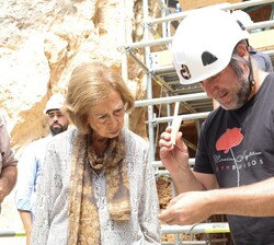 Su Majestad la Reina Doña Sofía observa uno de los objetos encontrados en la Cueva