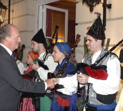 Don Juan Carlos y Doña Sofía saludan a unos gaiteros en la recepción a la colectividad española que Sus Majestades ofrecieron en la nueva sede de la C